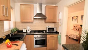 Una cucina moderna con mobili in legno, un fornello a gas, un forno a microonde e un forno integrato.