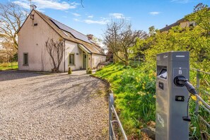 A building with a gravel driveway, a solar panel on the roof, and a charging station labeled 'B'. - 3 Bed in Keswick (oc-sz142) (Portinscale)
