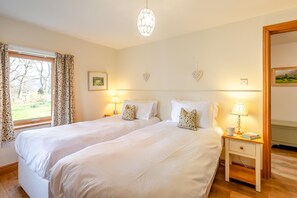 A double bed room with two bedside tables, a chandelier, and a window with curtains. - 3 Bed in Keswick (oc-sz142) (Portinscale)