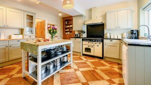 A kitchen with a central island, a stove, oven, and a sink. - 5 Bed in Keswick (oc-sz359) (Keswick)