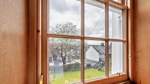 A window with a view of a garden and a house. - 1 Bed in Keswick (oc-sz472) (Keswick)