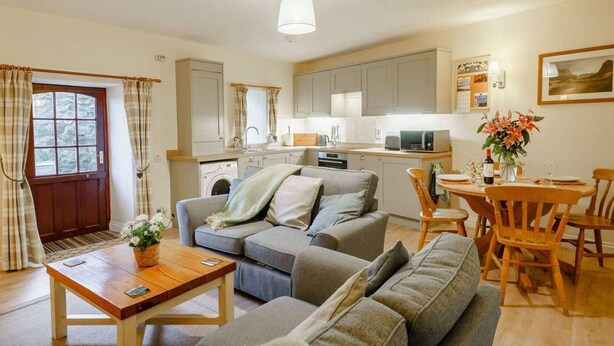 A compact living space with a sofa, dining table, and kitchen area. - 2 Bed in Penrith (oc-sz339) (Ullswater)