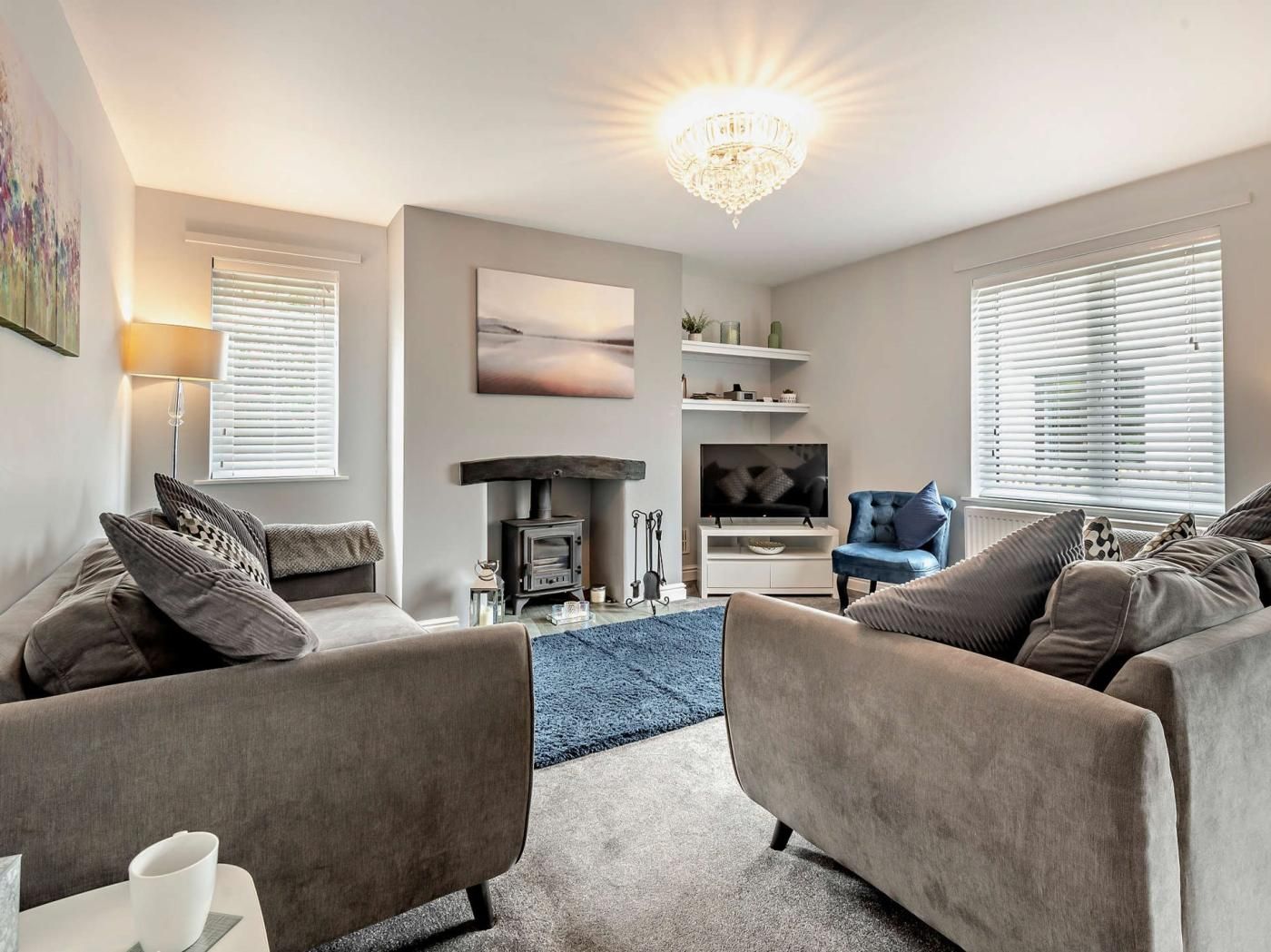 A modern living room with a fireplace, a television, and comfortable seating.