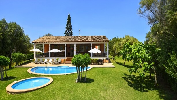 A house with a swimming pool, a patio with chairs and umbrellas, and a well-maintained lawn. - Villa in Son Servera With Private Pool & Beaches (Son Servera)