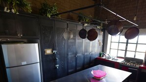 Una cucina con elettrodomestici in acciaio inossidabile, una rastrelliera per pentole a sospensione e un pavimento decorato.