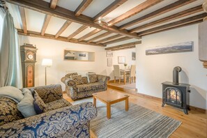 Ein gemütliches Wohnzimmer mit einer Couch, einem Couchtisch und einem Kamin.