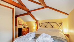 Una camera da letto con un letto, un comodino, una cassettiera e una lampada.
