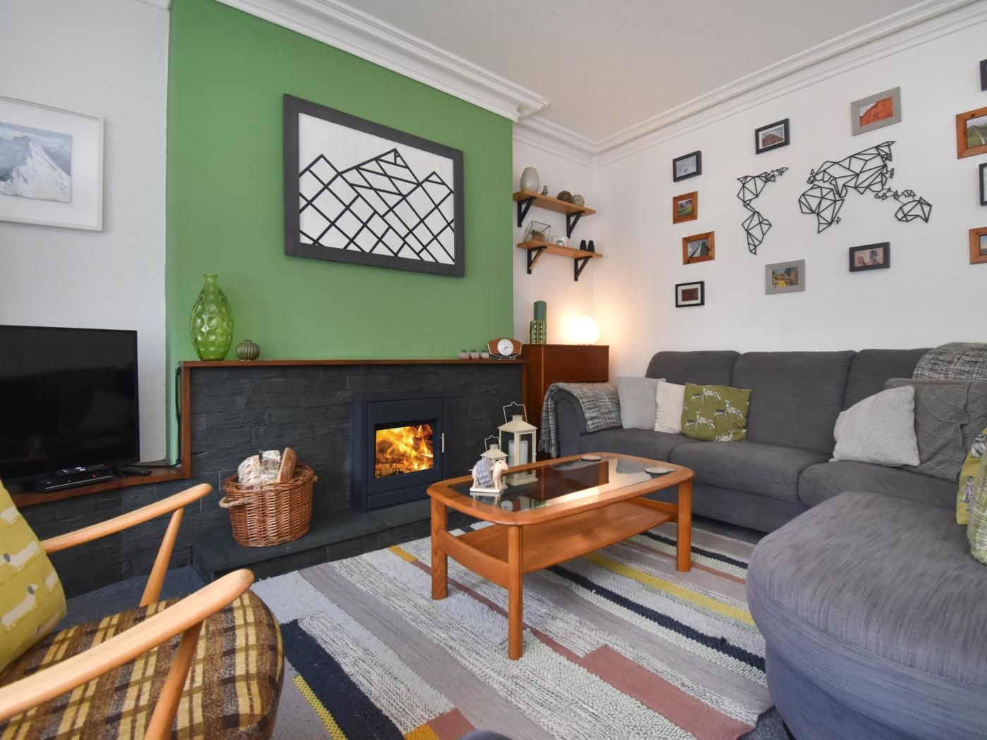 Ein Wohnzimmer mit Kamin, einer Couch, einem Fernseher und einem Couchtisch.