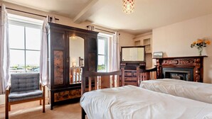 A hotel room with two beds, a large mirror, a fireplace, and a view of the outdoors.