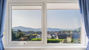 Eine Küche mit Fenster, Spüle und Blick auf eine Stadt und Berge.