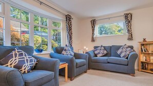 Ein Wohnzimmer mit zwei Sofas, einem Couchtisch und einem Bücherregal.
