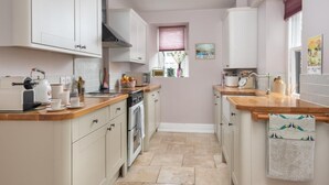 A kitchen with white cabinets, a wooden countertop, a stove, and a window with a view. - 2 Bed in Windermere (oc-sz306) (Windermere)