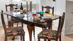 A dining table set with plates, glasses, and candles, surrounded by upholstered chairs. - 2 Bed in Windermere (oc-sz306) (Windermere)