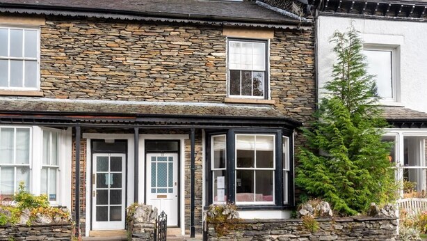 A stone house with a front porch, a door, and a window. - 2 Bed in Windermere (oc-sz306) (Windermere)