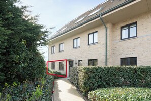 A pathway leading to a building with a brick facade and multiple windows. - 2 bedroom accommodation in Sint Idesbald (Sint Idesbald)