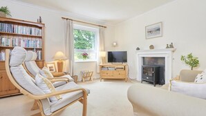 A living room with a fireplace, a television, a bookshelf, and a comfortable seating area. - 2 Bed in Keswick (oc-sz188) (Keswick)