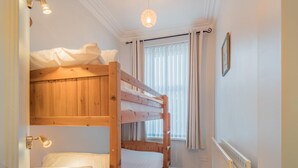 A bunk bed room with a bedside table, a hanging light fixture, and a window with curtains. - 2 Bed in Keswick (oc-sz019) (Keswick)
