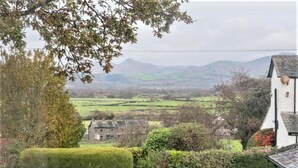 A rural landscape with a stone house, hedges, and distant mountains. - 1 Bed in Kirkby-in-furness (oc-sz463) (Kirkby Ireleth)