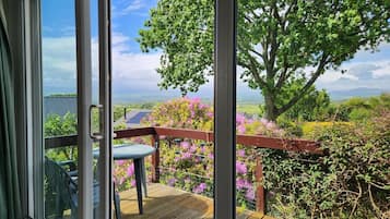 A deck with a view of a lake and mountains.