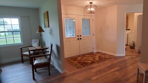 A room with a wooden floor, a desk with chairs, a window, and a door with glass panels. - Bicycles, fishing poles and lap tops invited! (Inverness)