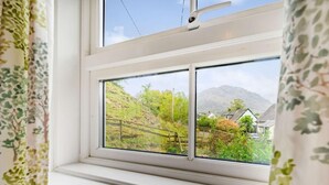 A window with a view of a rural landscape, including houses and hills. - 2 Bed in Keswick (oc-sz302) (Rosthwaite)