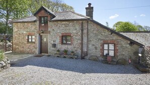 A stone house with a sloped roof, a chimney, and a gravel driveway. - 1 Bed in Holmrook (oc-sz471) (Irton with Santon)