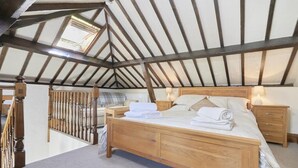A bedroom with a wooden bed, two bedside tables, a window, and a balcony. - 1 Bed in Holmrook (oc-sz471) (Irton with Santon)