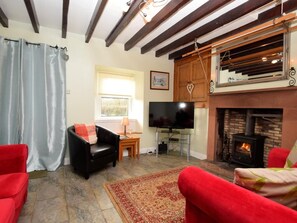 A living room with a fireplace, a television, and a stone floor. - 2 Bed in Holmrook (oc-sz205) (Irton with Santon)