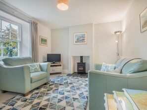 A living room with two sofas, a television, a fireplace, and a window with curtains. - 1 Bed in Keswick (oc-sz115) (Keswick)