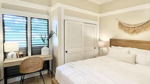 Ein Schlafzimmer mit Bett, Schreibtisch, Stuhl, Lampe und einem Fenster mit Jalousien.