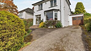A two-story house with a gravel driveway, a garage, and a well-maintained garden. - 3 Bed in Keswick (oc-sz249) (Keswick)
