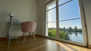 Ein Zimmer mit großem Fenster, einem Sessel und einer Heizung.