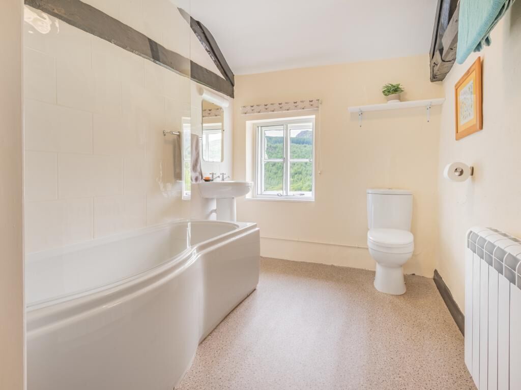 A bathroom with a bathtub, toilet, and sink.