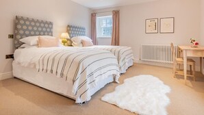 A bedroom with two beds, a desk, a radiator, and a window with curtains. - 4 Bed in Penrith (oc-sz264) (Askham)