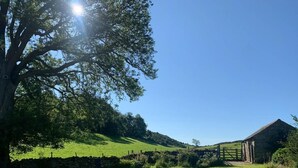 A rural landscape with a stone barn, a stone wall, and a grassy field. - 4 Bed in Penrith (oc-sz264) (Askham)