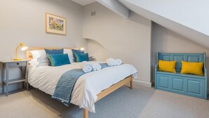 A bedroom with a bed, bedside tables, a bench, and a picture on the wall. - 3 Bed in Keswick (oc-sz029) (Keswick)