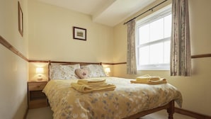 A bedroom with a bed, bedside lamps, a window with curtains, and a picture on the wall. - 2 Bed in Wasdale Head (oc-sz551) (Wasdale)