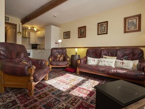 A living room with a patterned rug, leather sofas, and a wooden coffee table. - 2 Bed in Wasdale Head (oc-sz551) (Wasdale)