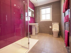 Um banheiro moderno com box de vidro, vaso sanitário e pia.
