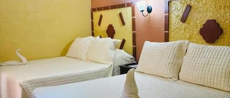 Two single beds with white bedding, a wall clock, and a decorative wall panel.