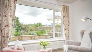 A room with a large window, two chairs, a table, and a lamp. - 3 Bed in Keswick (oc-sz007) (Keswick)