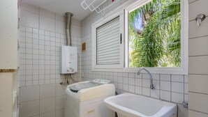 A bathroom with white tiles, a window with blinds, a sink, and a washing machine. - Beautiful Apt 450m From Lagoa da Conceicao Crm0201 (Florianópolis)