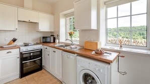 A modern kitchen with white cabinets, a microwave, a toaster, and a washing machine. - 1 Bed in Penrith (oc-sz176) (Lazonby)