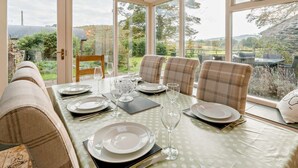 A dining area with a table set for four, large windows, and a view of the outdoors. - 4 Bed in Sedbergh (oc-sz595) (Millthrop)