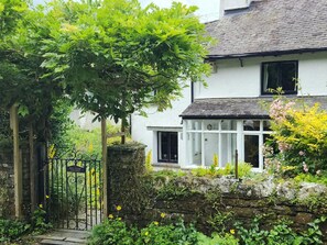 A white house with a stone wall and a metal gate labeled 'Bull Close Cottage.' - 2 Bed in Ambleside (oc-84633) (Skelwith)