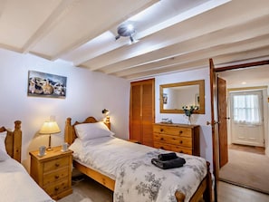 A bedroom with a bed, bedside tables, a dresser, a mirror, and a painting on the wall. - 1 Bed in Kirkby Stephen (oc-sz355) (Newbiggin-on-Lune)