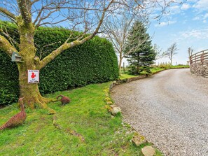 A gravel road with a stone wall on the right, a hedge on the left, and a sign warning of red squirrels. - 1 Bed in Kirkby Stephen (oc-sz355) (Newbiggin-on-Lune)