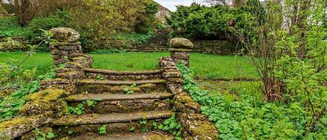 A stone staircase leading up to a house with a flag.