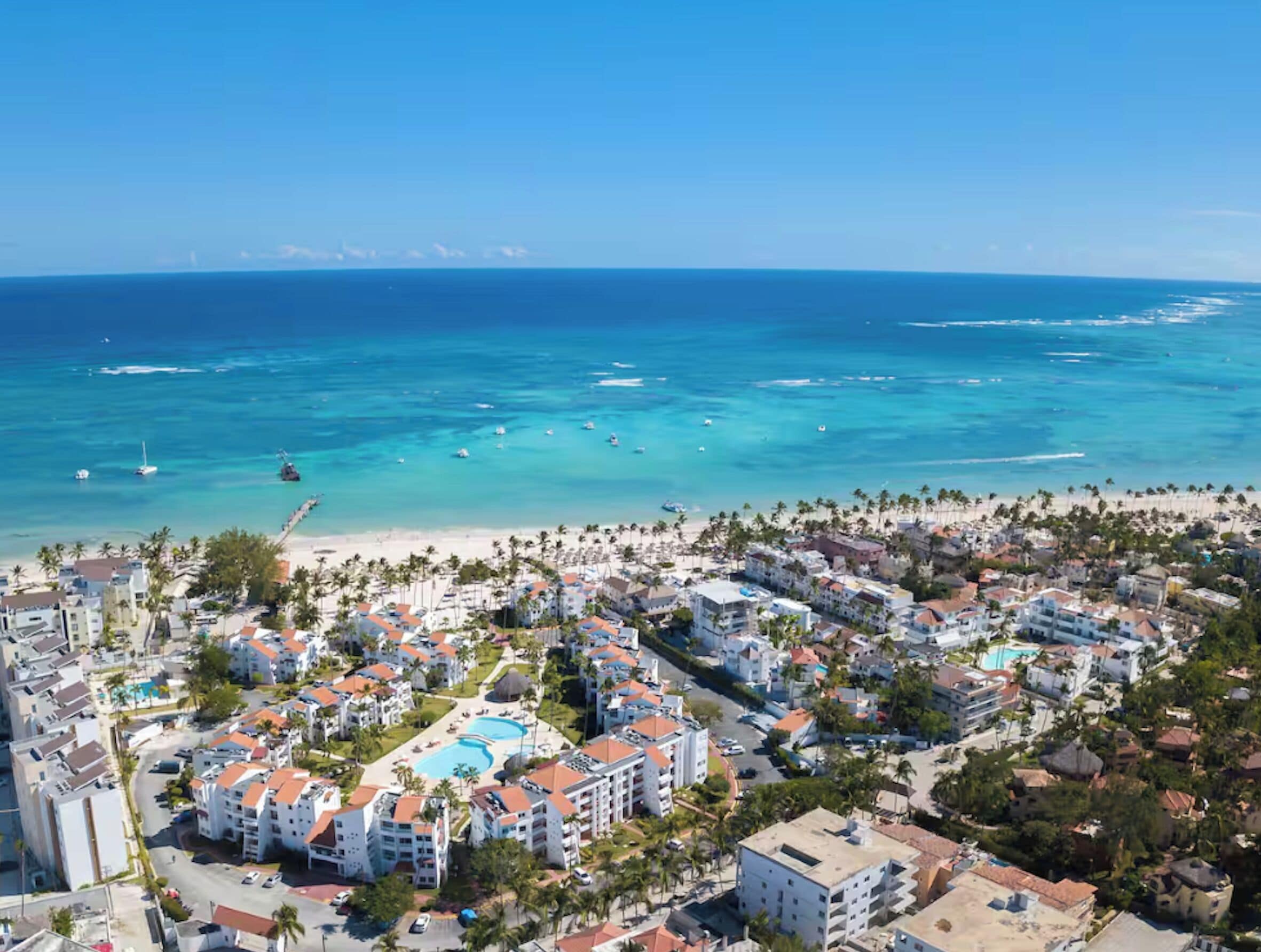 Une station balnéaire avec des propriétés situées en bord de mer, une piscine et une vue dégagée sur l’océan.