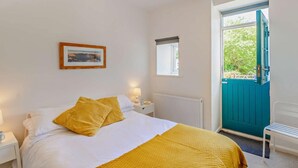 A bedroom with a bed, bedside tables, a window, a door, and a view of greenery outside. - 1 Bed in Cockermouth (oc-sz160) (Lorton)
